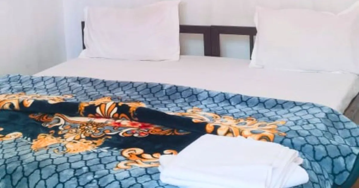 Valencia Suite premium room with clean white bedding and blue quilt