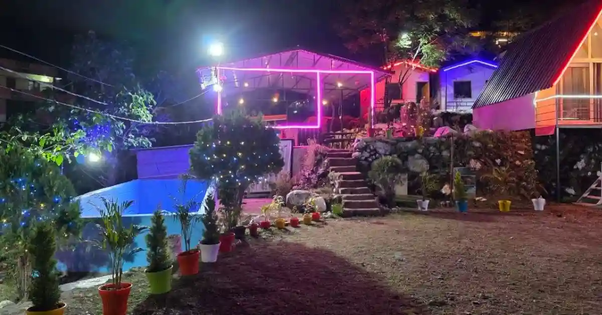 Swimming pool at Valencia River Resort Rishikesh at night with garden and neon lights