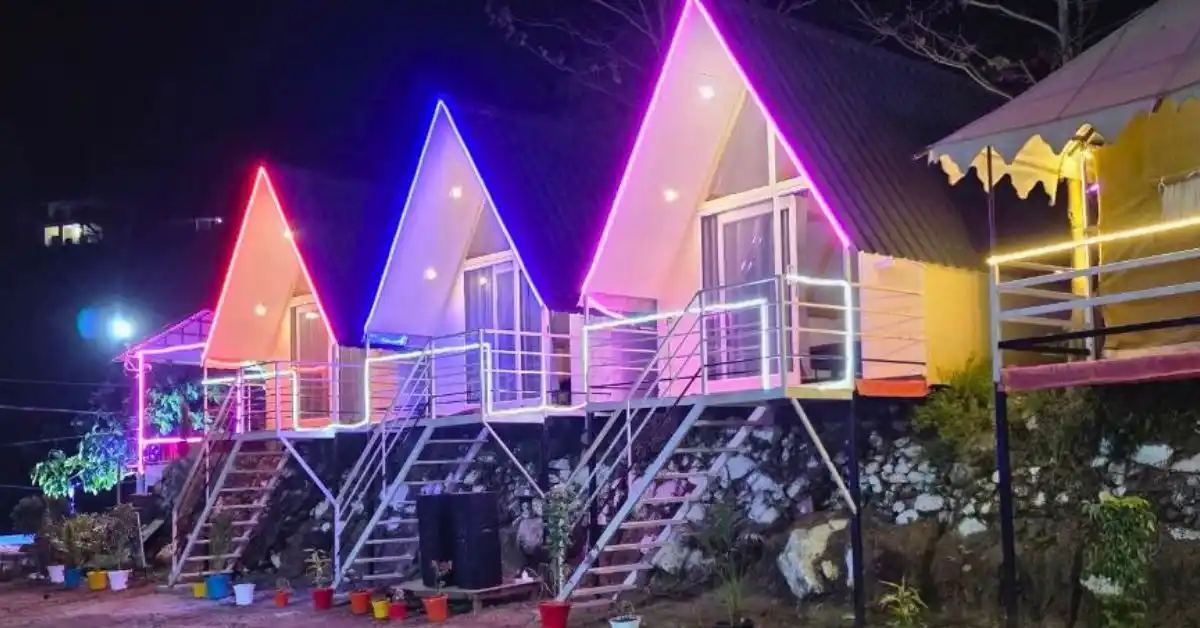 Premium A-frame cottages at Valencia River Resort Rishikesh lit up at night