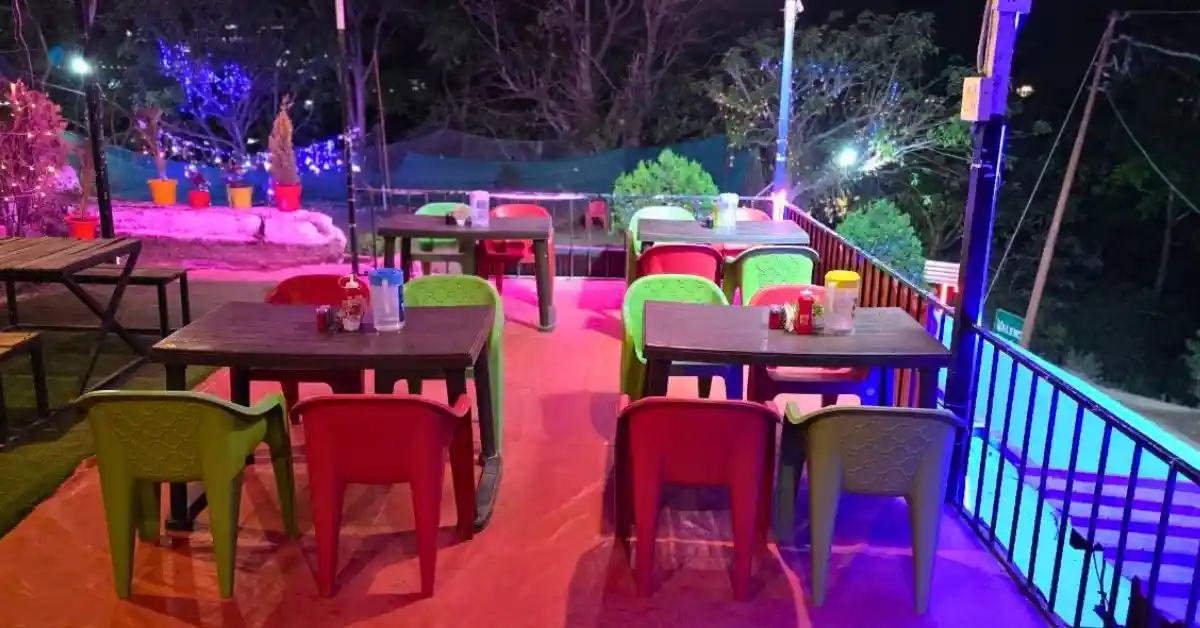 Open air dining area at night with colorful chairs