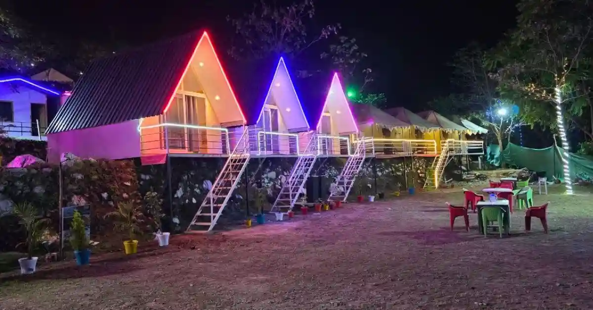 Valencia River Resort A-frame cottages lawn at night with dining area